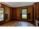 Charming living room featuring wood-paneled walls, hardwood floors, and natural light from the windows at 117 Carolina Forest Rd, Chapel Hill, NC 27516