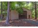 Large outbuilding with tall door and small access door has neutral color and is surrounded by lush trees at 117 Carolina Forest Rd, Chapel Hill, NC 27516