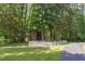 Outbuilding with fenced in yard and driveway is surrounded by mature trees at 117 Carolina Forest Rd, Chapel Hill, NC 27516