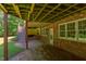 Covered patio with brick flooring and open wood rafter ceilings at 117 Carolina Forest Rd, Chapel Hill, NC 27516