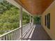 Enjoy the outdoors on this cozy porch with wood ceilings and columns with trees in background at 117 Carolina Forest Rd, Chapel Hill, NC 27516