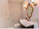 Charming powder room with decorative mirror, vanity, and sconce lighting at 117 Carolina Forest Rd, Chapel Hill, NC 27516