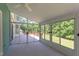 Enclosed sunroom featuring glass windows and access to an outdoor deck overlooking the lush backyard at 117 Carolina Forest Rd, Chapel Hill, NC 27516