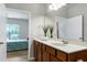 Bathroom vanity featuring wood cabinets, light countertops and views to the bedroom at 118 Rosedale Creek Dr, Durham, NC 27703