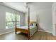 Bedroom features wood floors, 4-poster bed, and a window with natural light at 118 Rosedale Creek Dr, Durham, NC 27703