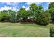 Landscaped front yard with mature trees on a sunny day with blue skies and clouds at 118 Rosedale Creek Dr, Durham, NC 27703