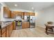 Well-lit kitchen featuring stainless steel appliances, wood cabinets, and laminate floors for a modern and functional space at 118 Rosedale Creek Dr, Durham, NC 27703