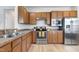 Well-lit kitchen featuring stainless steel appliances, wood cabinets, and laminate floors for a modern and functional space at 118 Rosedale Creek Dr, Durham, NC 27703