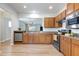 Well-lit kitchen featuring stainless steel appliances, wood cabinets, and an open layout with views into other rooms at 118 Rosedale Creek Dr, Durham, NC 27703