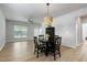Spacious living room with a modern light fixture, wood flooring, and dining area at 118 Rosedale Creek Dr, Durham, NC 27703