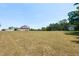 Serene backyard showcasing a beautifully maintained lawn and a charming brick home at 120 Gentle Rain Dr, Garner, NC 27529