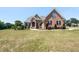 Brick home featuring manicured lawn, mature trees, and beautiful architectural details at 120 Gentle Rain Dr, Garner, NC 27529