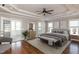 Virtually staged main bedroom featuring an attached sunroom, large windows, modern furniture, and hardwood floors at 120 Gentle Rain Dr, Garner, NC 27529
