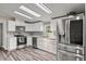 Modern kitchen with stainless steel appliances, white cabinets, and a stylish backsplash at 12294 Nc Hwy 96 S, Dunn, NC 28334