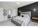 Comfortable bedroom featuring an upholstered bed, accent wall, and a full-length mirror, enhancing the room's spacious feel at 1602 Bowery Dr, Raleigh, NC 27607