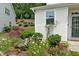 Charming home featuring a lush garden with vibrant flowers, complementing the home's light exterior and well-maintained lawn at 161 Walking Path Pl, Hillsborough, NC 27278