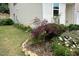 Well-manicured lawn, enhanced by colorful flowerbeds and a Japanese maple, adding character to the home's exterior at 161 Walking Path Pl, Hillsborough, NC 27278