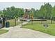 Community playground with climbing structures, slides, and picnic tables, ideal for Gathering enjoyment and outdoor fun at 161 Walking Path Pl, Hillsborough, NC 27278