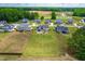 Wide aerial view of home showcasing expansive lot, landscaping, and neighborhood pond in a tranquil setting at 173 Vinson Park Dr, Archer Lodge, NC 27527