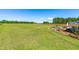 Vast backyard with green grass, trees, and a landscape bed at edge of patio area at 173 Vinson Park Dr, Archer Lodge, NC 27527
