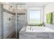Modern bathroom with soaking tub, a glass enclosed shower and decorative tile details at 173 Vinson Park Dr, Archer Lodge, NC 27527