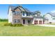 Charming two-story home with a stone facade, well-manicured lawn, and a three-car garage, showcasing curb appeal at 173 Vinson Park Dr, Archer Lodge, NC 27527