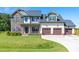 Beautiful two-story home with manicured lawn, three car garage, and stone and siding details at 173 Vinson Park Dr, Archer Lodge, NC 27527