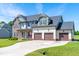 Beautiful two-story home with a stone accent, a three-car garage, and a long driveway on a well-maintained lawn at 173 Vinson Park Dr, Archer Lodge, NC 27527