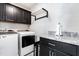 Well-equipped laundry room with granite countertops, black cabinets and modern washer and dryer at 173 Vinson Park Dr, Archer Lodge, NC 27527