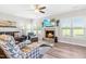Inviting living room with a fireplace, TV, hardwood floors, and large windows at 173 Vinson Park Dr, Archer Lodge, NC 27527