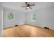 A bedroom with hardwood floors and two windows allowing for plenty of natural light at 1837 Garrett House Trl, Burlington, NC 27215