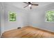 A simple bedroom features hardwood floors and has two windows for natural light at 1837 Garrett House Trl, Burlington, NC 27215