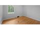 A bright bedroom with hardwood floors, a large window, and neutral wall colors at 1837 Garrett House Trl, Burlington, NC 27215