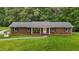 Charming brick home featuring a cozy front porch and well-maintained lawn at 1837 Garrett House Trl, Burlington, NC 27215
