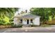Charming one-story home featuring a welcoming front porch, mature trees, and landscaping at 203 Brick St, Wake Forest, NC 27587