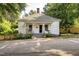Charming one-story home featuring a welcoming front porch, mature trees, and landscaping at 203 Brick St, Wake Forest, NC 27587