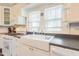 Bright eat-in kitchen with modern appliances, white cabinetry, and a farmhouse sink at 203 Brick St, Wake Forest, NC 27587
