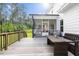 Spacious back deck with a seating area, dining table, and views of the screened-in porch and backyard at 211 Education Dr, Spring Lake, NC 28390