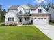 Charming two-story home featuring a landscaped lawn, brick accents, and a two-car garage at 211 Education Dr, Spring Lake, NC 28390