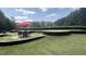 Outdoor patio area features tables and chairs under a red umbrella for entertaining guests at 211 Education Dr, Spring Lake, NC 28390