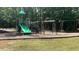 Community playground with swings, slide and other play equipment surrounded by mature trees at 211 Education Dr, Spring Lake, NC 28390