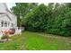 Well-maintained backyard with stone pathway, lush lawn, patio deck with outdoor seating, and mature landscaping at 2112 Tulare Ct, Raleigh, NC 27612