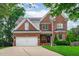 Charming brick two-story home featuring manicured lawn, two-car garage and mature trees at 2112 Tulare Ct, Raleigh, NC 27612