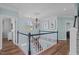 Upper level hallway featuring hardwood floors, a chandelier, and beautiful wall decor at 2112 Tulare Ct, Raleigh, NC 27612