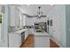 Modern kitchen with stainless steel appliances, an island with cooktop and granite countertops, and white cabinetry at 2112 Tulare Ct, Raleigh, NC 27612