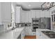 Kitchen features white cabinetry, stainless steel appliances, granite countertops, and lots of natural light at 2112 Tulare Ct, Raleigh, NC 27612