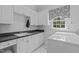 Well-organized laundry room with upper and lower cabinets, a sink, a window, and a washer and dryer at 2112 Tulare Ct, Raleigh, NC 27612