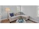 Cozy living room has a plush sectional sofa, an ottoman, hardwood floors, and natural light from the window at 2112 Tulare Ct, Raleigh, NC 27612