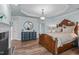 Spacious main bedroom with hardwood floors, fireplace, and decorative chandelier at 2112 Tulare Ct, Raleigh, NC 27612