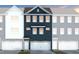 Modern townhouse with a two-car garage and beautiful navy blue siding between white and grey units at 2137 Grouse Ski Cir, Apex, NC 27523